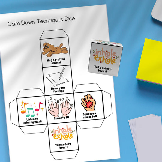 a Printable emotional regulation dice on a blue desk next to some yellow and white papers